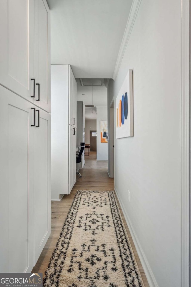 hall with crown molding and light hardwood / wood-style floors