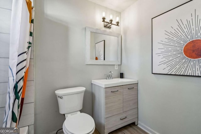 bathroom with toilet, vanity, and a shower with curtain