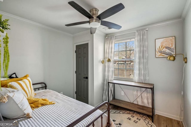 bedroom featuring ceiling fan, wood-type flooring, and ornamental molding