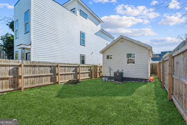 rear view of house featuring central AC and a yard