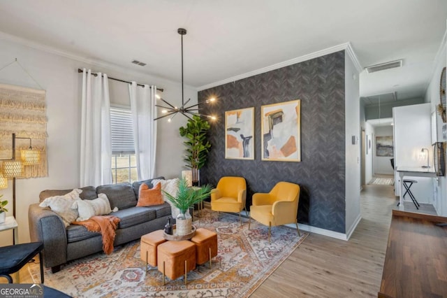 living room with wood-type flooring, crown molding, and an inviting chandelier