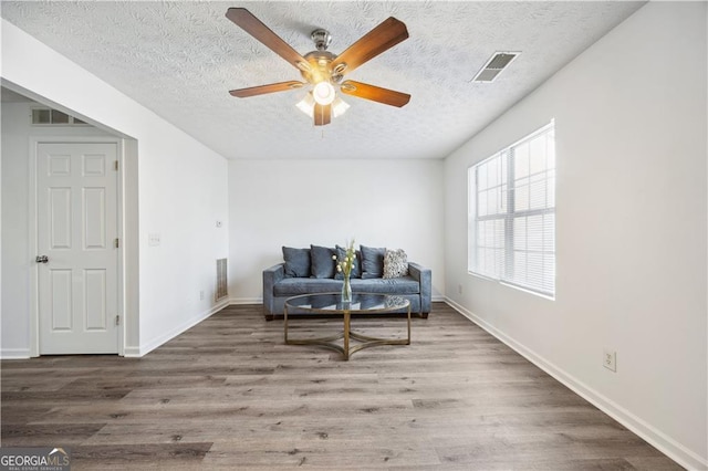 sitting room featuring ceiling fan, a textured ceiling, and hardwood / wood-style floors