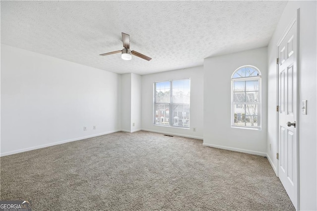 carpeted spare room with a textured ceiling and ceiling fan