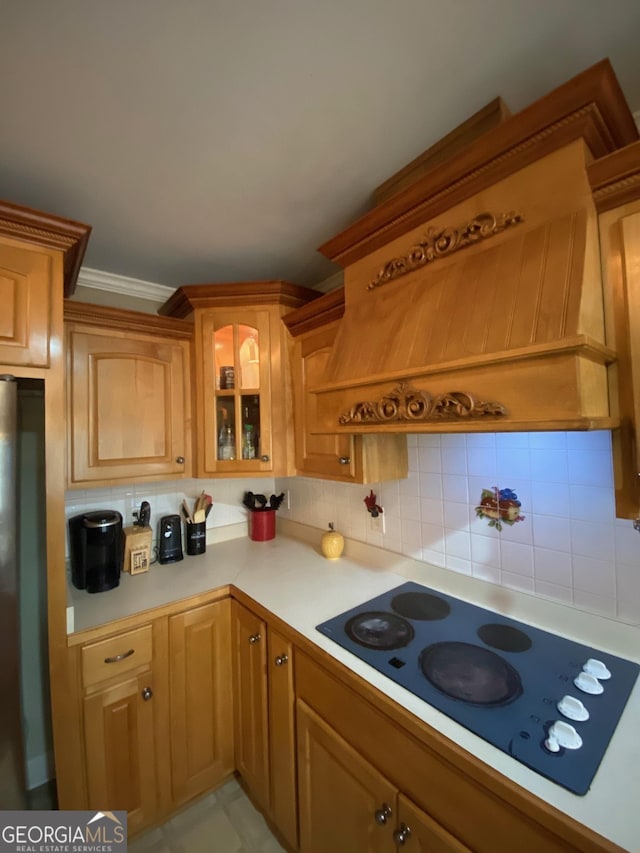 kitchen featuring ornamental molding, electric stovetop, backsplash, and stainless steel refrigerator