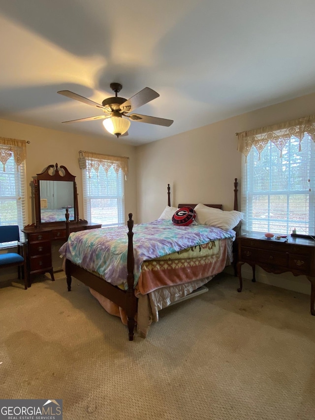 bedroom featuring multiple windows, ceiling fan, and carpet flooring