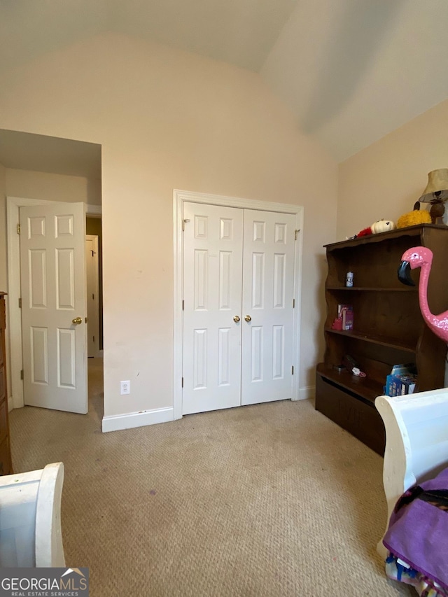 carpeted bedroom featuring lofted ceiling and a closet