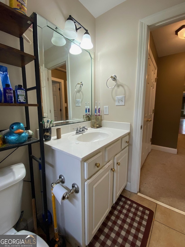 bathroom with tile patterned flooring, vanity, and toilet