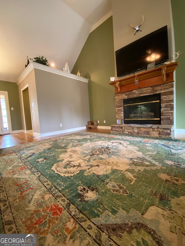 unfurnished living room with vaulted ceiling, ornamental molding, and a fireplace