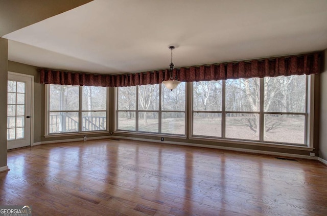 unfurnished dining area featuring hardwood / wood-style floors