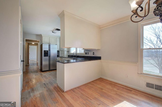 kitchen featuring kitchen peninsula, stainless steel refrigerator with ice dispenser, light wood-type flooring, white cabinets, and sink