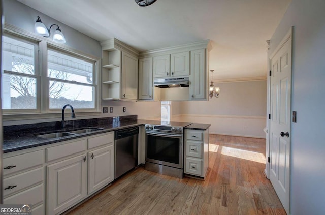 kitchen with light hardwood / wood-style floors, stainless steel appliances, a chandelier, pendant lighting, and sink