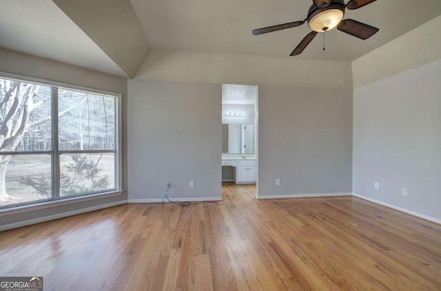 unfurnished living room featuring ceiling fan, a healthy amount of sunlight, vaulted ceiling, and light hardwood / wood-style flooring