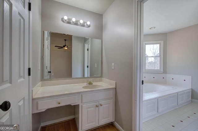 bathroom featuring ceiling fan, a bathtub, and vanity