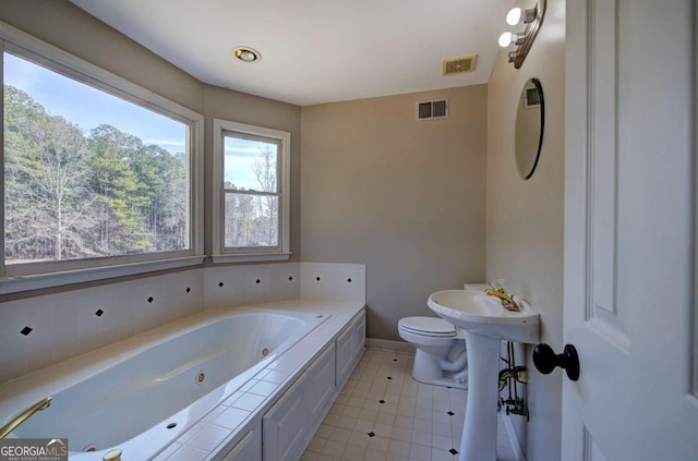 bathroom with toilet, a bathtub, and tile patterned flooring