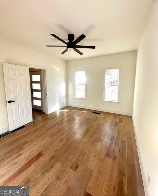 empty room featuring ceiling fan and hardwood / wood-style floors