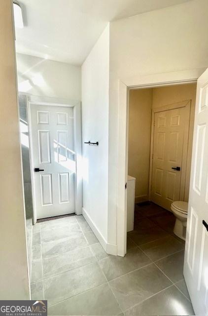 bathroom with toilet and tile patterned floors