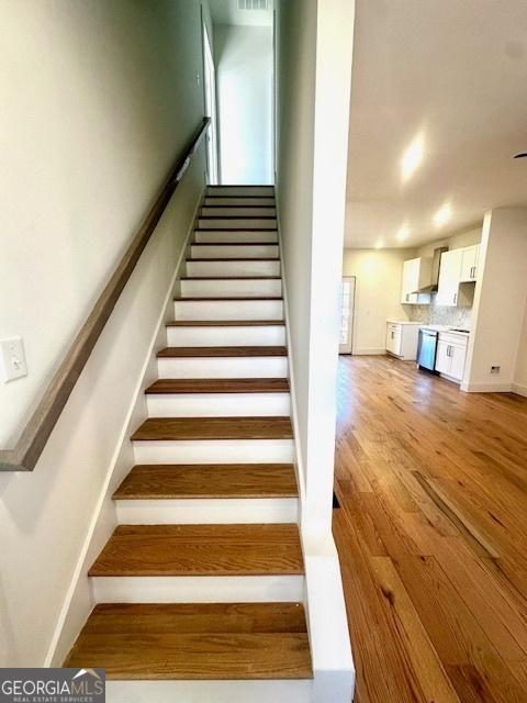 staircase with hardwood / wood-style flooring