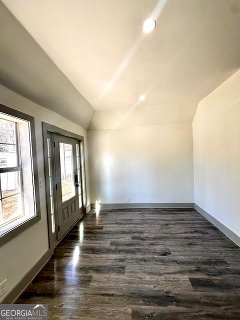 foyer with dark hardwood / wood-style floors and vaulted ceiling