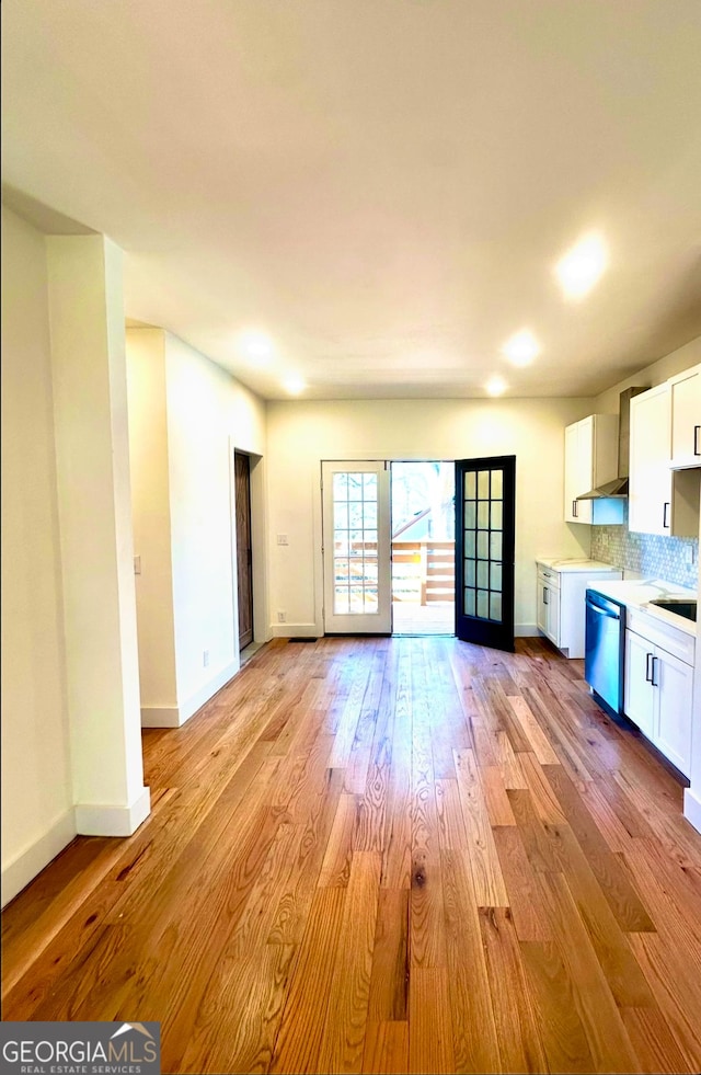 kitchen featuring decorative backsplash, dishwasher, white cabinets, and light hardwood / wood-style floors