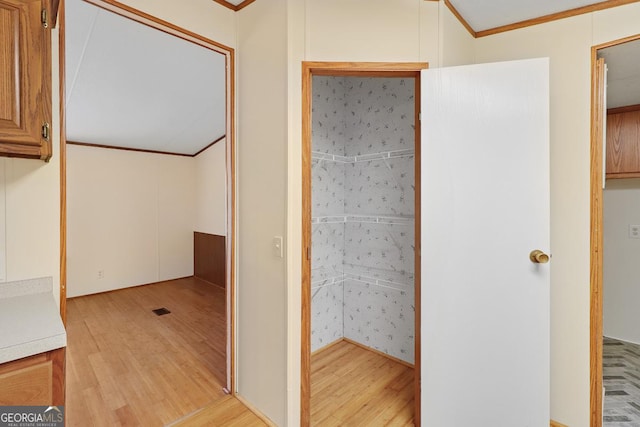 interior space with light hardwood / wood-style floors and crown molding