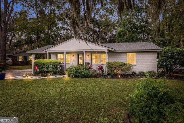 ranch-style house with covered porch and a front yard