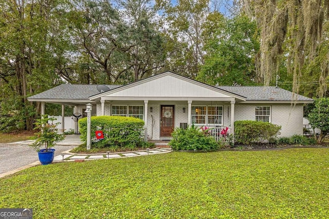 ranch-style house with covered porch, a carport, and a front yard