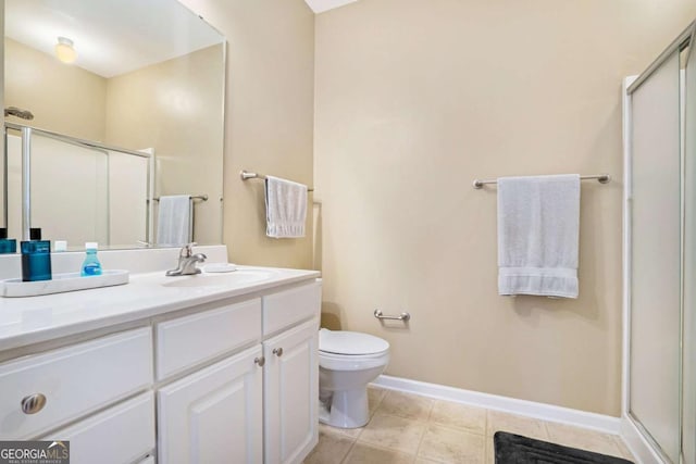 bathroom featuring toilet, vanity, tile patterned flooring, and a shower with door