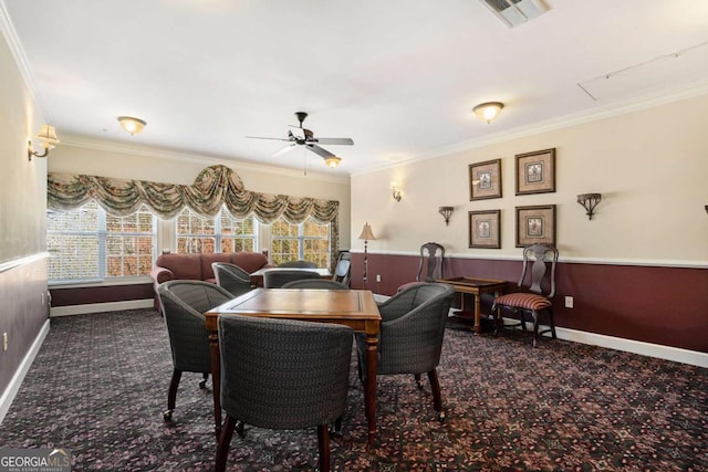 carpeted dining room featuring ceiling fan and crown molding