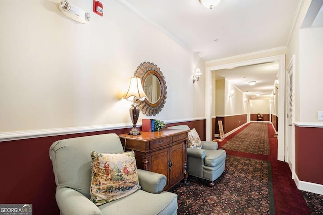 sitting room featuring ornamental molding and dark carpet