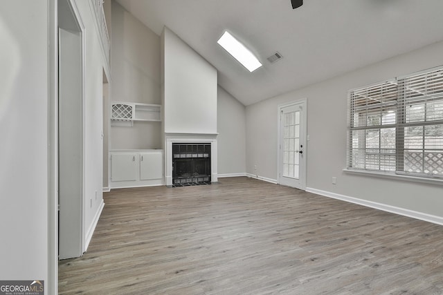 unfurnished living room with vaulted ceiling and light wood-type flooring