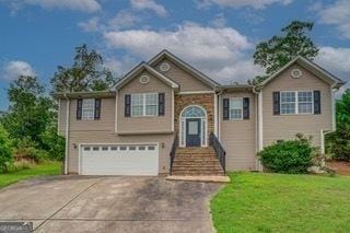 raised ranch with a garage and a front lawn