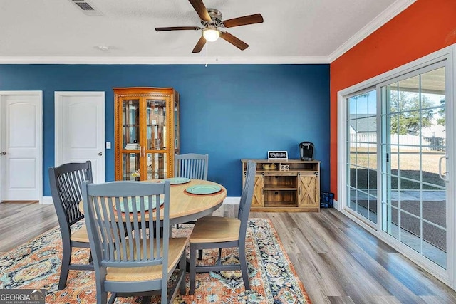 dining space with ceiling fan, ornamental molding, and hardwood / wood-style floors