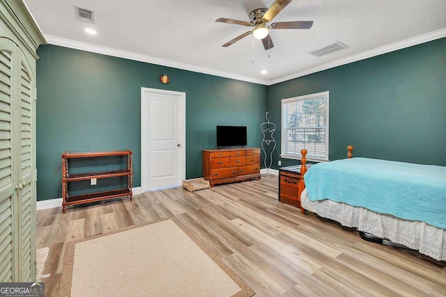 bedroom featuring a textured ceiling, ceiling fan, and ornamental molding