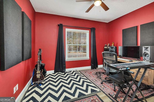 home office with a textured ceiling, ceiling fan, and wood-type flooring