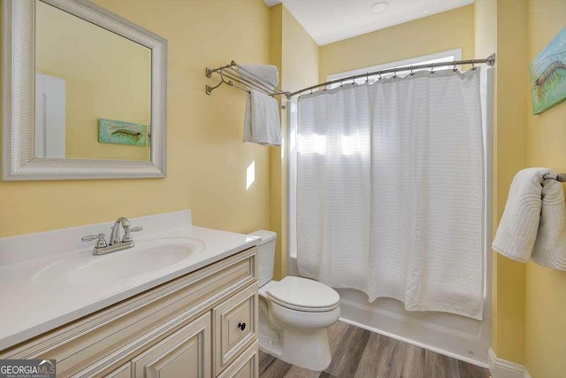 full bathroom with hardwood / wood-style floors, brick ceiling, vanity, toilet, and shower / tub combo with curtain