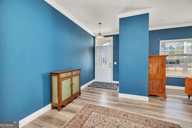 entrance foyer with crown molding and light hardwood / wood-style flooring