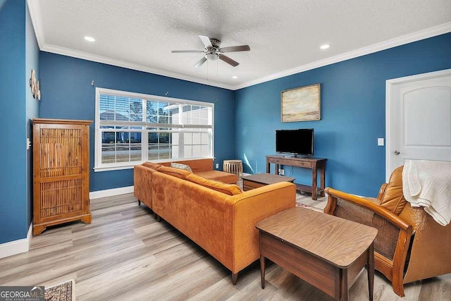 living room with light wood-type flooring, ceiling fan, crown molding, and a textured ceiling