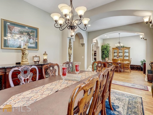 dining space with an inviting chandelier and light hardwood / wood-style floors