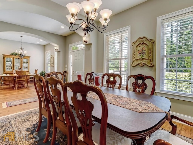 dining space with wood-type flooring and a chandelier