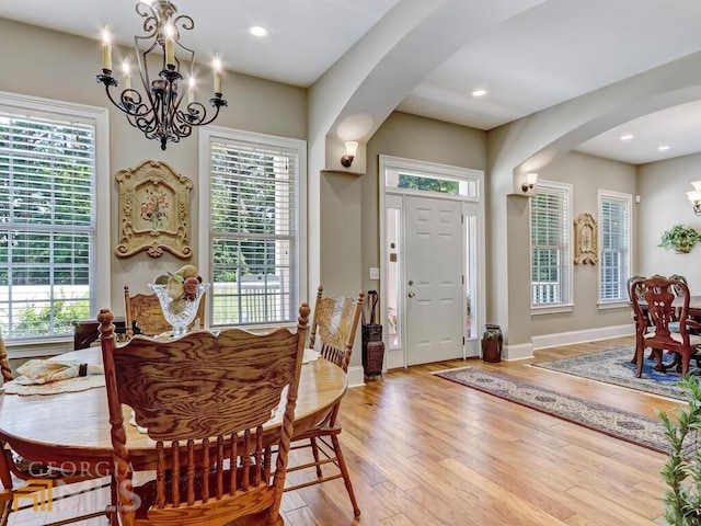 dining room featuring a healthy amount of sunlight, light wood-type flooring, and a chandelier