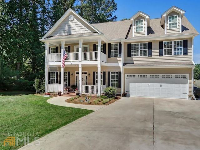 view of front of home featuring a garage, a front lawn, and covered porch