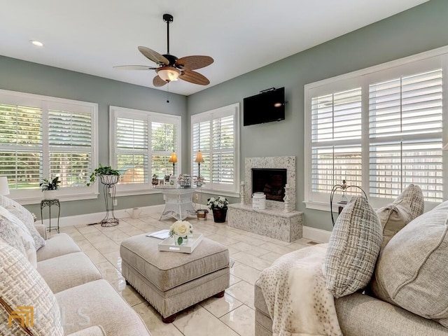 living room featuring ceiling fan and a fireplace