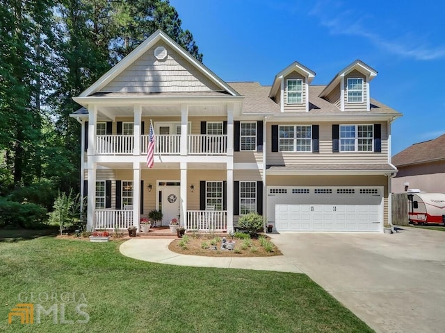 view of front of home with a front yard, a porch, and a garage