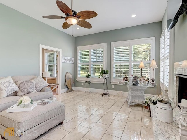 living room featuring ceiling fan and a healthy amount of sunlight