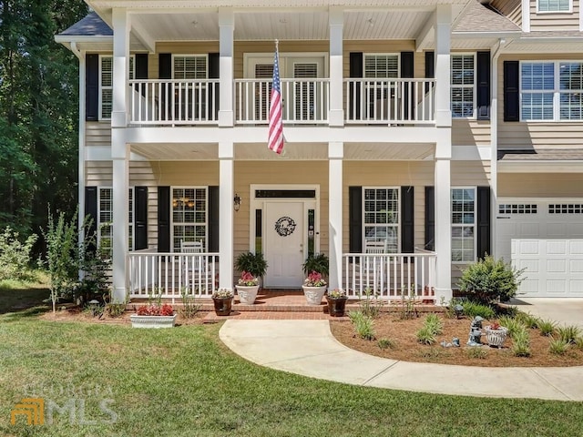 view of front of home with a front lawn, covered porch, and a garage