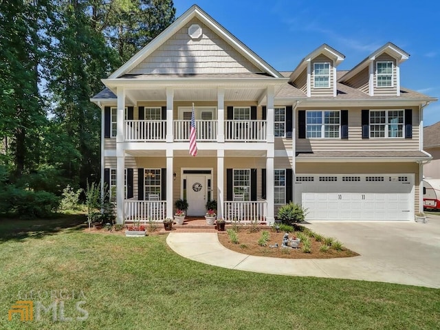 view of front of property with a front yard, covered porch, and a garage