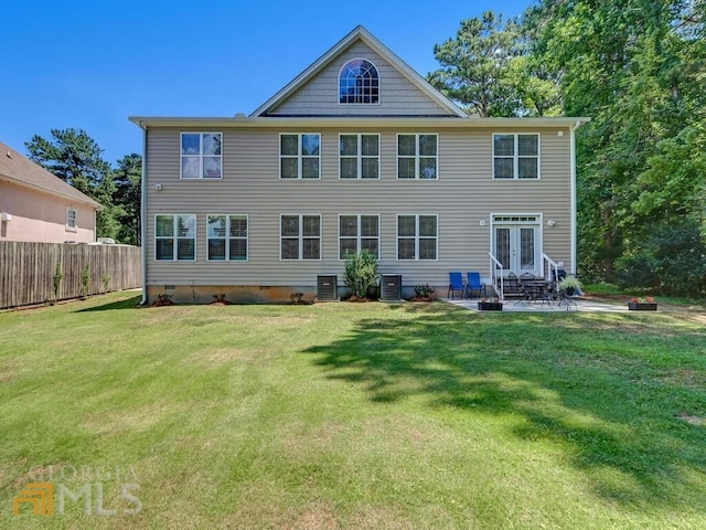 rear view of property with a patio area, central air condition unit, french doors, and a lawn