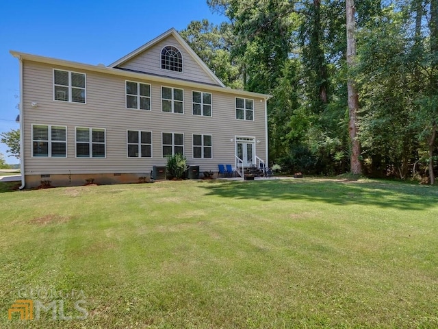 back of property with central air condition unit and a yard