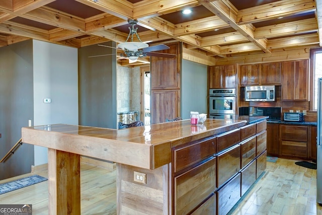 kitchen featuring a kitchen island, stainless steel appliances, plenty of natural light, light wood-type flooring, and ceiling fan