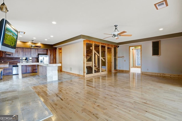 unfurnished living room with ceiling fan and light hardwood / wood-style flooring